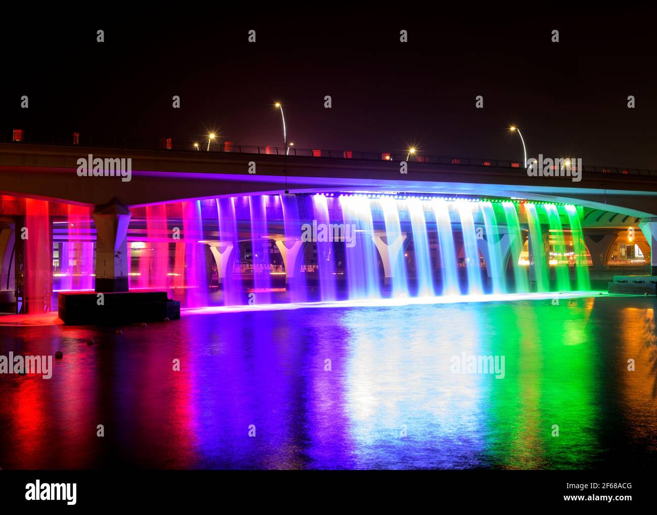 Cascade illuminée et colorée de la promenade du canal de dubaï à Dubaï. La chute d'eau fait partie du développement du canal d'eau de Dubaï. Émirats arabes Unis. Banque D'Images