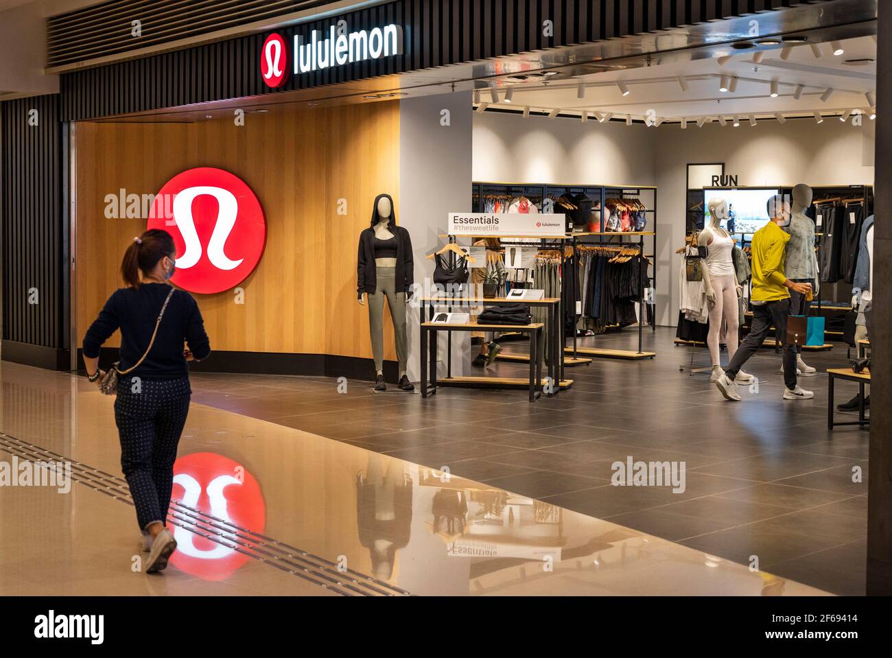 Un acheteur passe devant le groupe de vêtements de sport canadien, le logo Lululemon et le magasin vu à Hong Kong. Banque D'Images