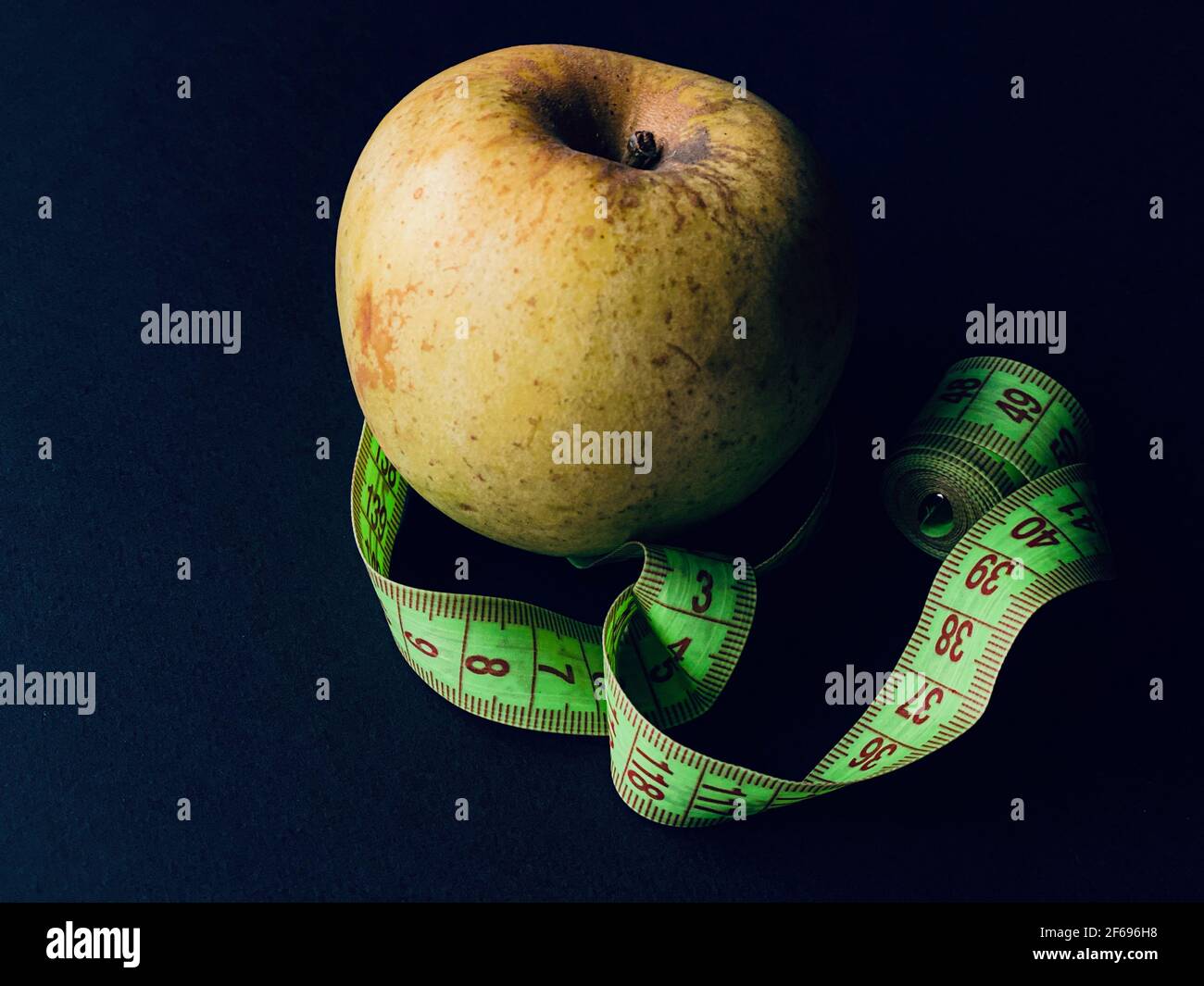 pomme verte avec mètre sur fond noir Banque D'Images