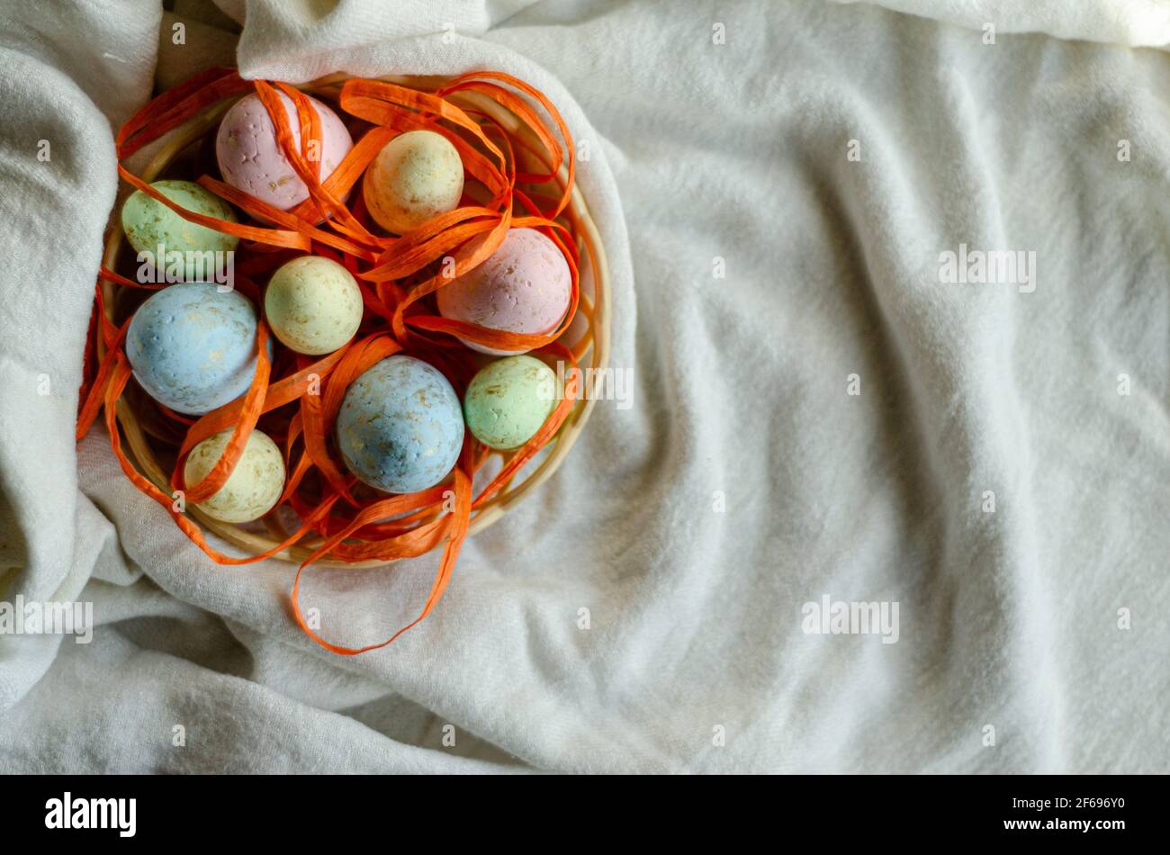 oeufs de pâques dans un panier sur une nappe blanche, placer pour le tex Banque D'Images