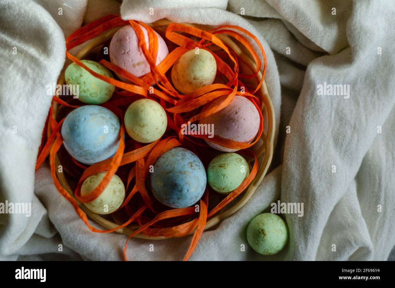 oeufs de pâques dans un panier sur une nappe blanche, vue de dessus, place pour le tex Banque D'Images