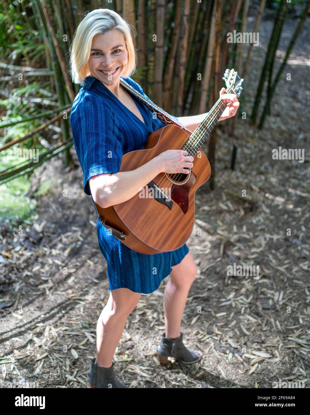 jeune femme jouant de la guitare et chantant dans le jardin de la forêt de  bambou Photo Stock - Alamy