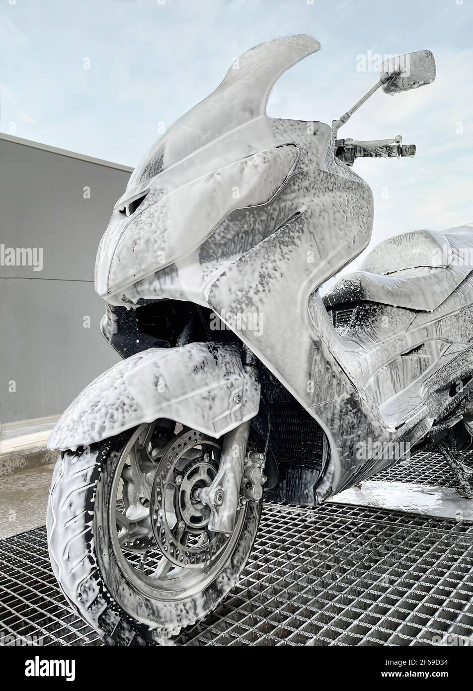 scooter entièrement enduit dans un lavage de voiture, lavage du scooter  dans un magasin de lavage de voiture et de moto, gros plan, vertical Photo  Stock - Alamy