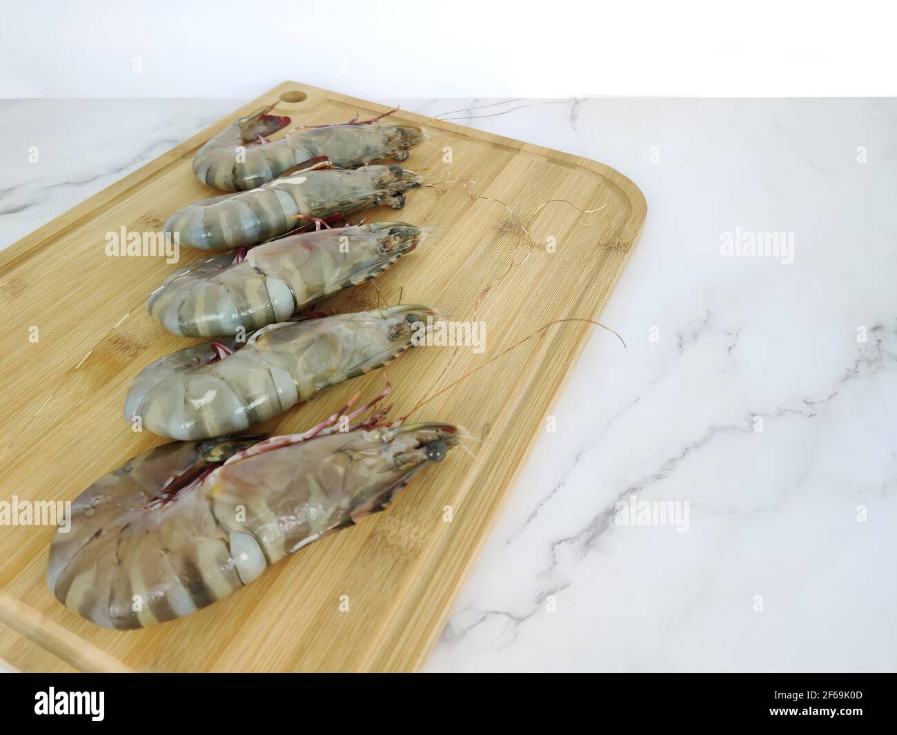 Crevettes fraîches sur une planche à découper en bois. Points de mise au point sélective. Banque D'Images
