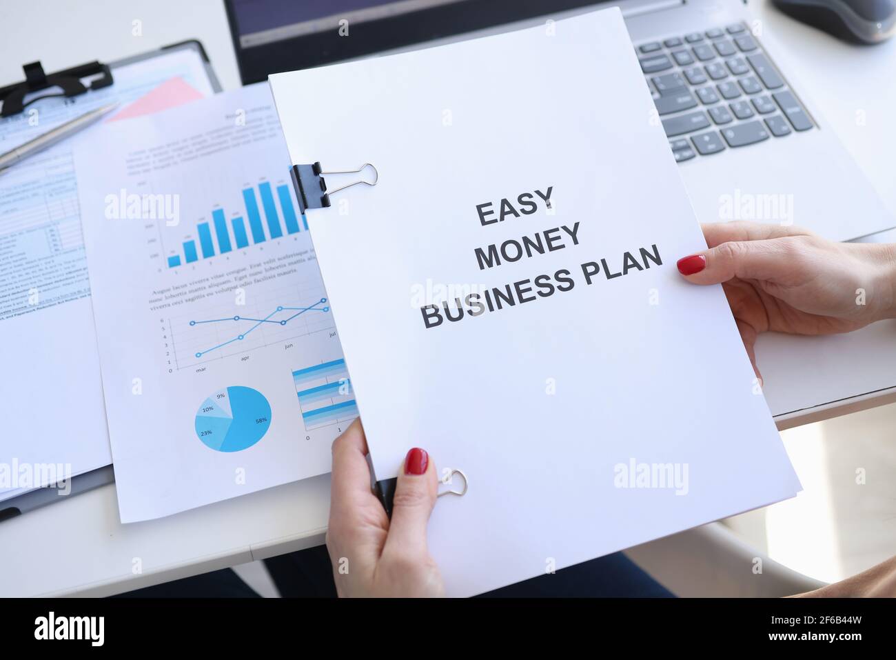 Femme tenant des documents avec le titre Easy Money business plan dans ses mains en gros plan Banque D'Images