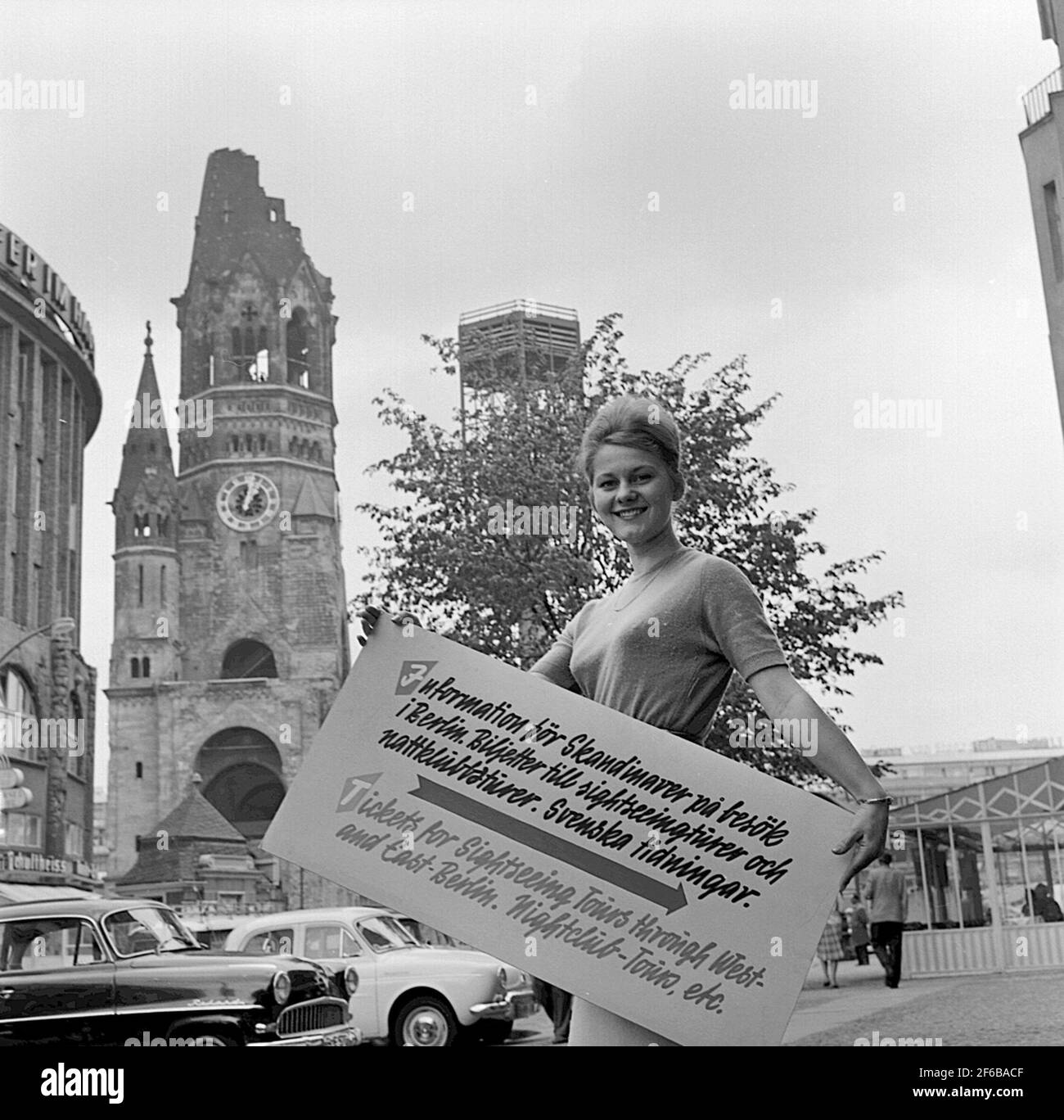 Le personnel de l'agence de voyage de la compagnie de chemin de fer de Berlin tient un panneau d'information avec le texte: "Information pour les Scandinaves en visite à Berlin. Billets pour des excursions et des excursions en discothèque. Journaux suédois. Billets pour des excursions dans Berlin Ouest et est. Boîte de nuit - Tours, etc.' . Banque D'Images