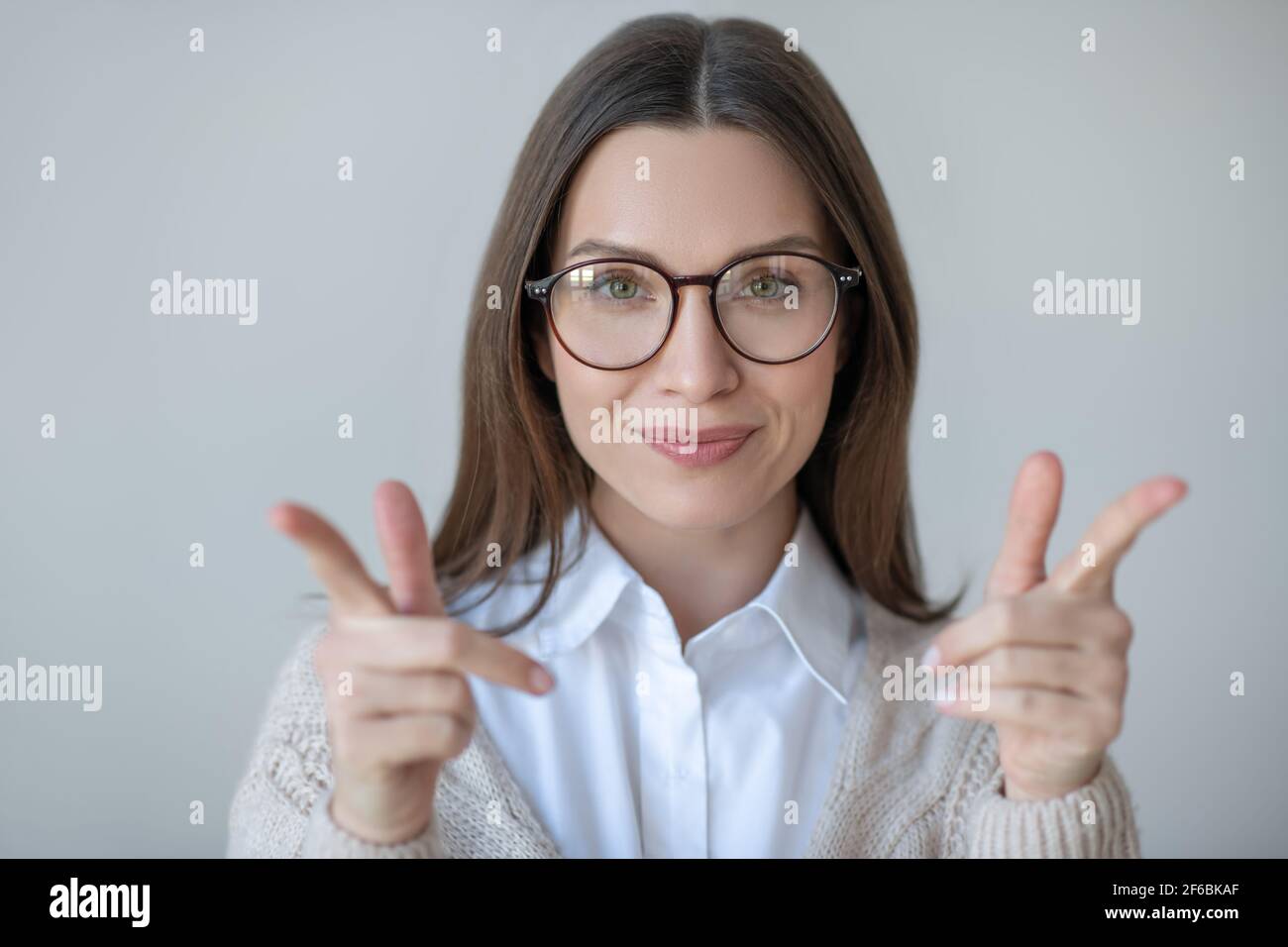 Image de la taille haute de la femme à cheveux longs dans les lunettes de vue regardant confiant Banque D'Images