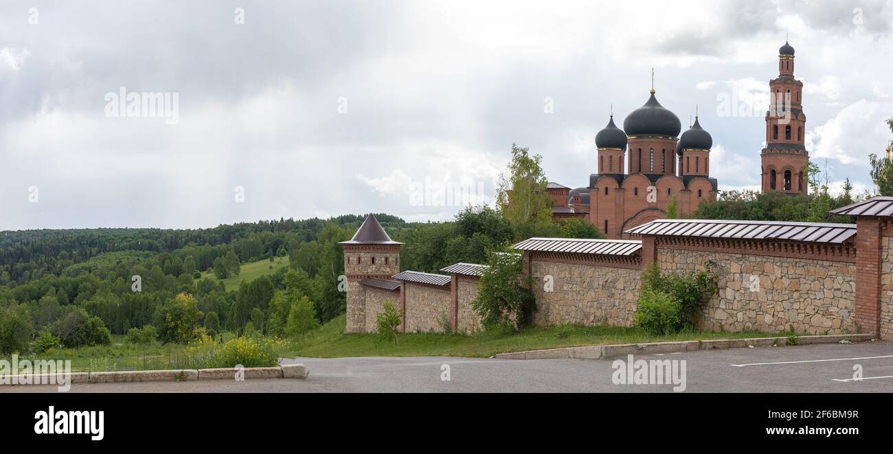 Paysage de forêts et de bâtiments en briques avec église, clocher, clôture du monastère de Saint-Georges d'Uspensky, buissons Saints près de la ville d'Ufa avec horizon de Banque D'Images