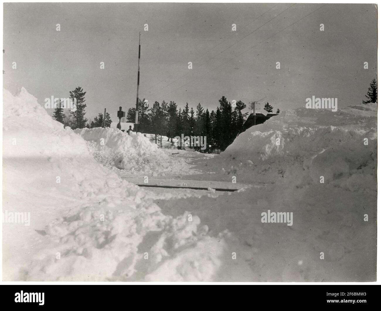 Empålen sur la ligne Orsa-Sveg prise à Febuari 1931. L'une des transitions de routes bloquées qui a été débouchée à travers les toits de neige Banque D'Images