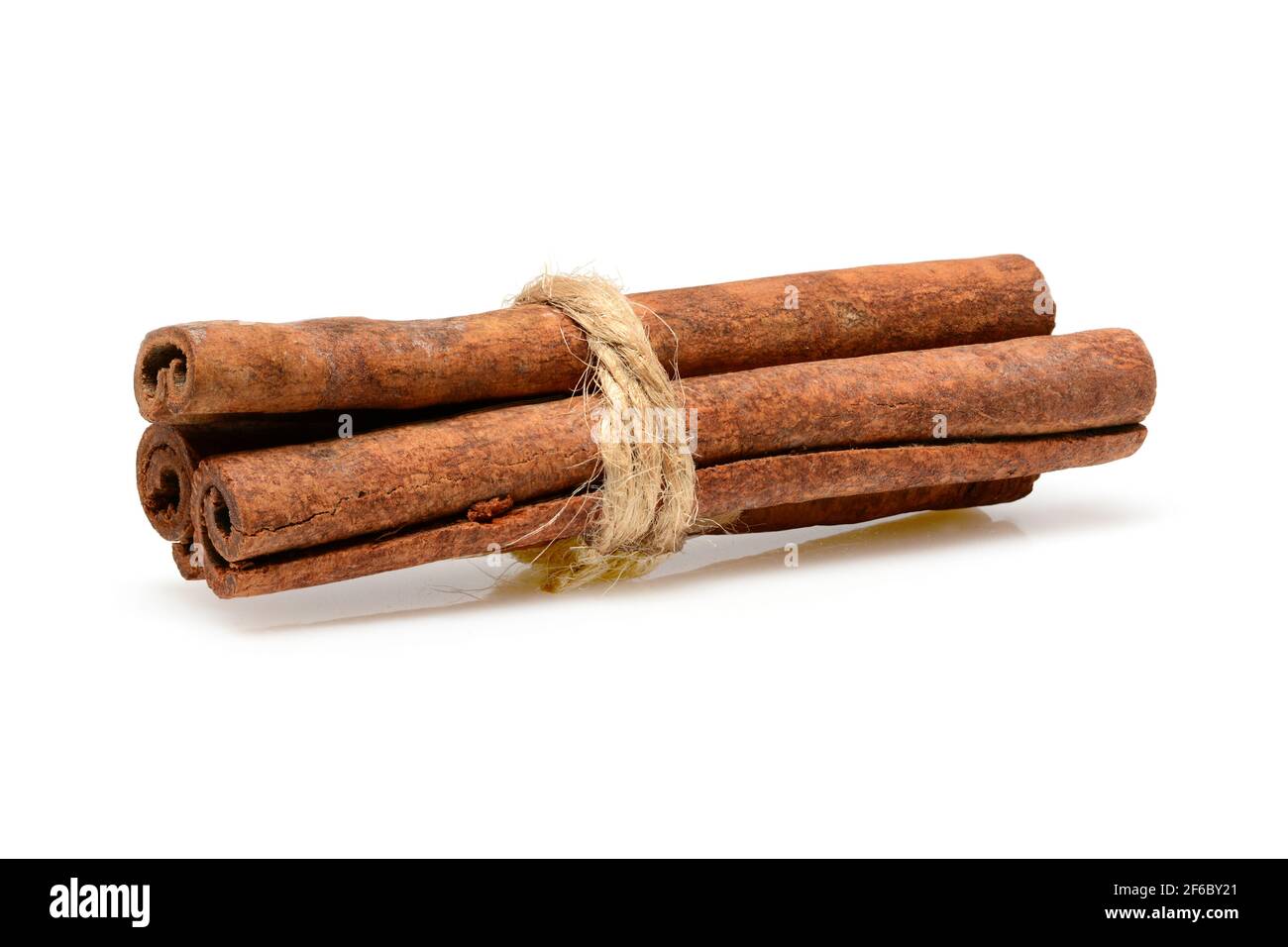 Bâtons de cannelle noués avec une corde de jute pour la cuisine et les cosmétiques. Macro de gros plan isolée sur fond blanc avec ombre. Profondeur de champ totale, haute réso Banque D'Images