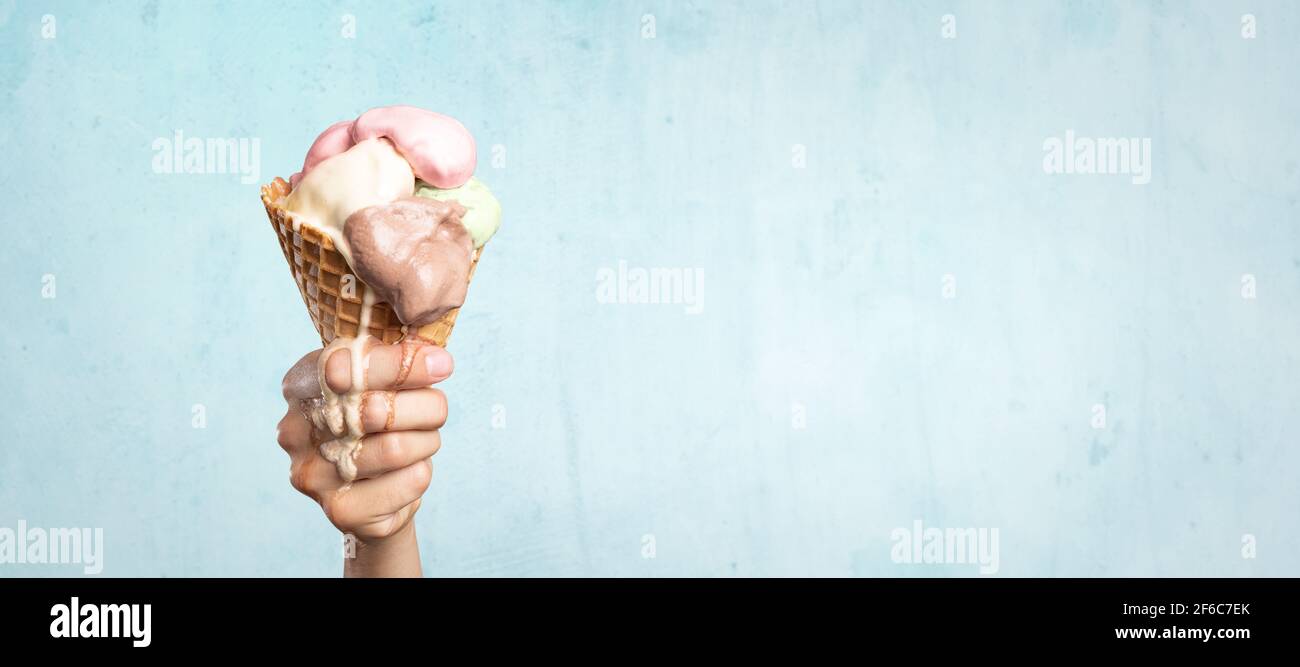 Cône de crème glacée à la fusion tenu à la main Banque D'Images