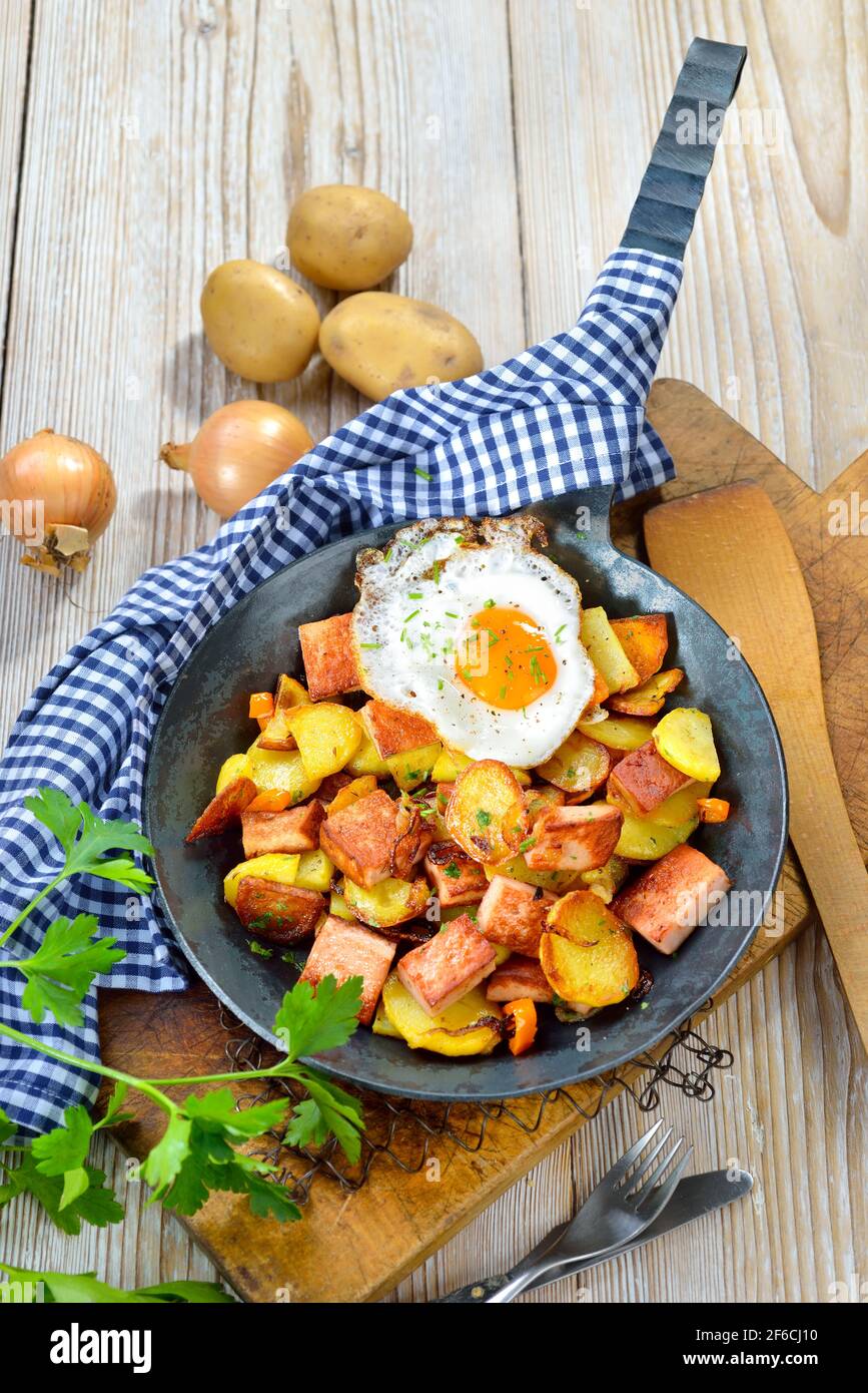 Pommes de terre frites avec pain de viande et un œuf frit, appelé groestrl bavarois, souvent servi dans une poêle Banque D'Images