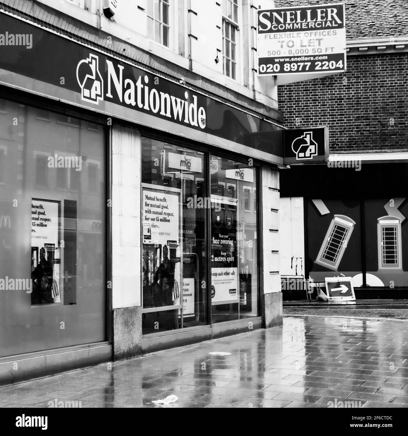 Image en noir et blanc branche High Street du bâtiment national La Banque de la société sans personne en un jour de pluie humide Banque D'Images