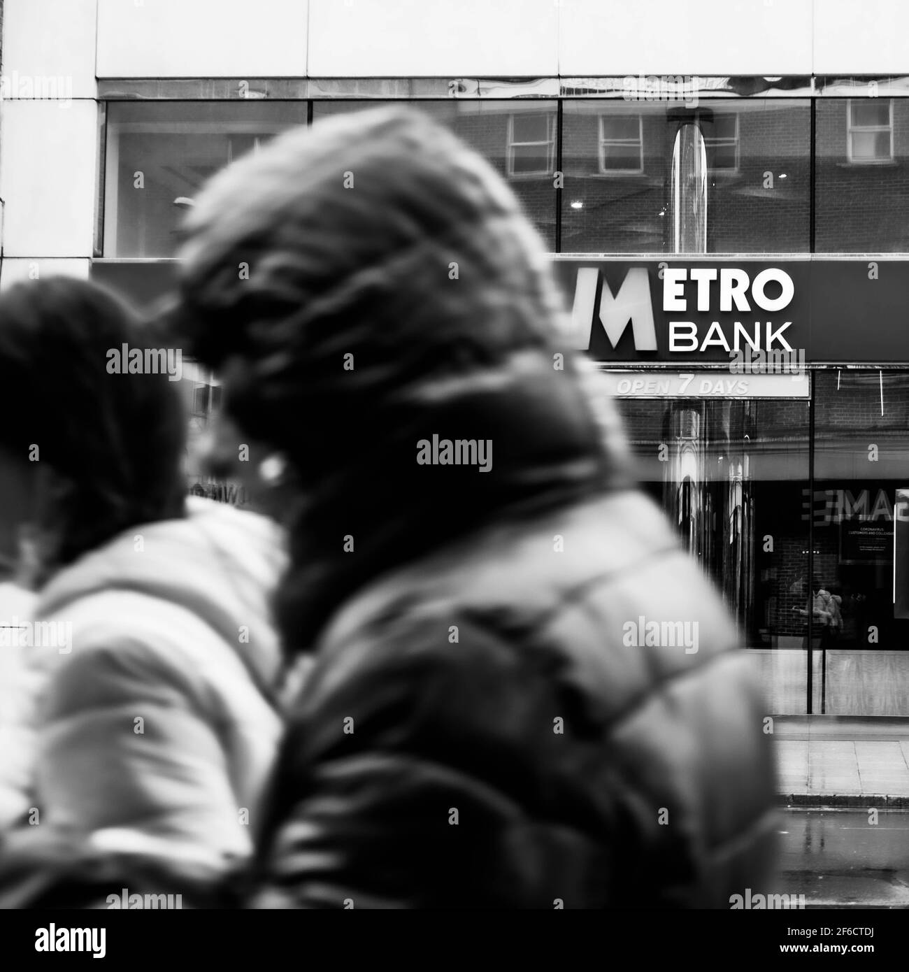 Personnes marchant devant UNE succursale de High Street de Metro Bank Par une journée de pluie Banque D'Images