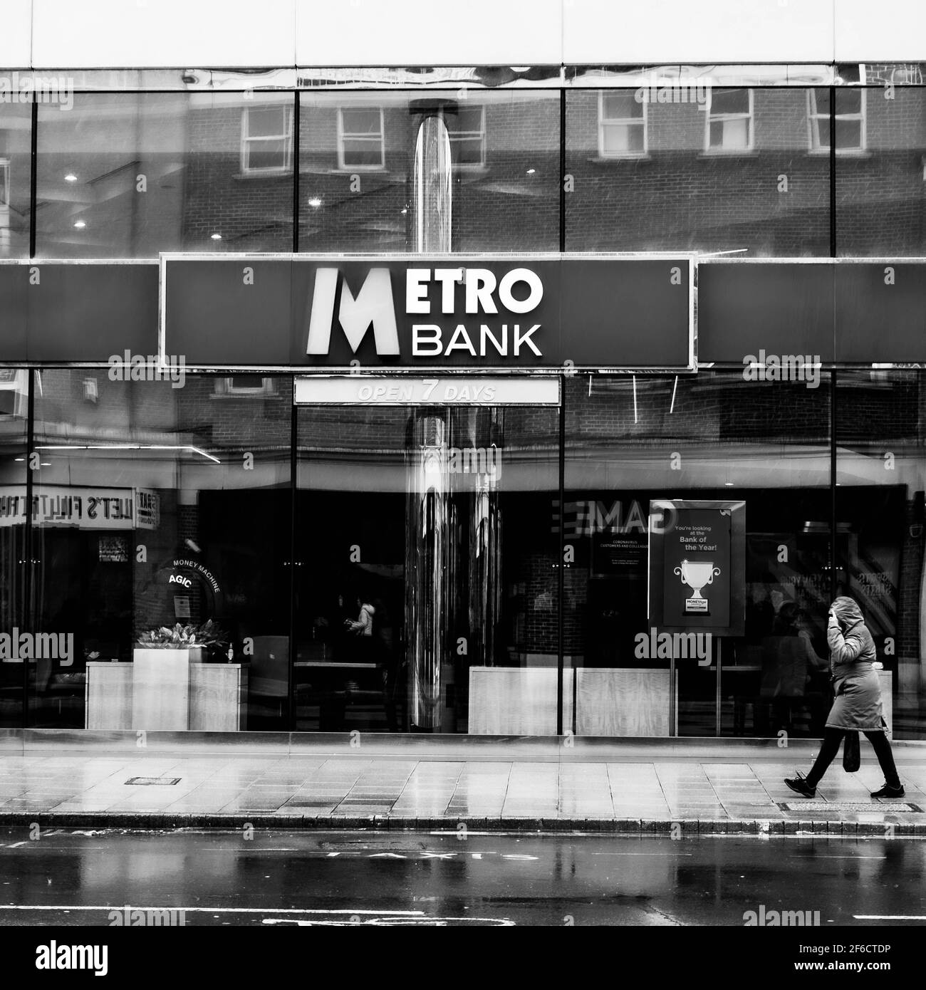 Personnes marchant devant UNE succursale de High Street de Metro Bank Par une journée de pluie Banque D'Images