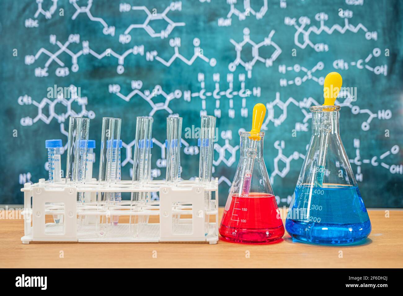 Verrerie de laboratoire avec fond de tableau noir et diverses formules chimiques. Banque D'Images