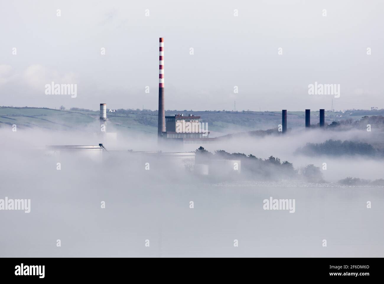 Aghada, Cork, Irlande. 31 mars, 2021.le soleil du matin commence à se démailler le brouillard marin qui enveloppe les réservoirs de stockage de la raffinerie de pétrole et de la centrale électrique à Aghada, Co. Cork, Irlande. - crédit; David Creedon / Alamy Live News Banque D'Images