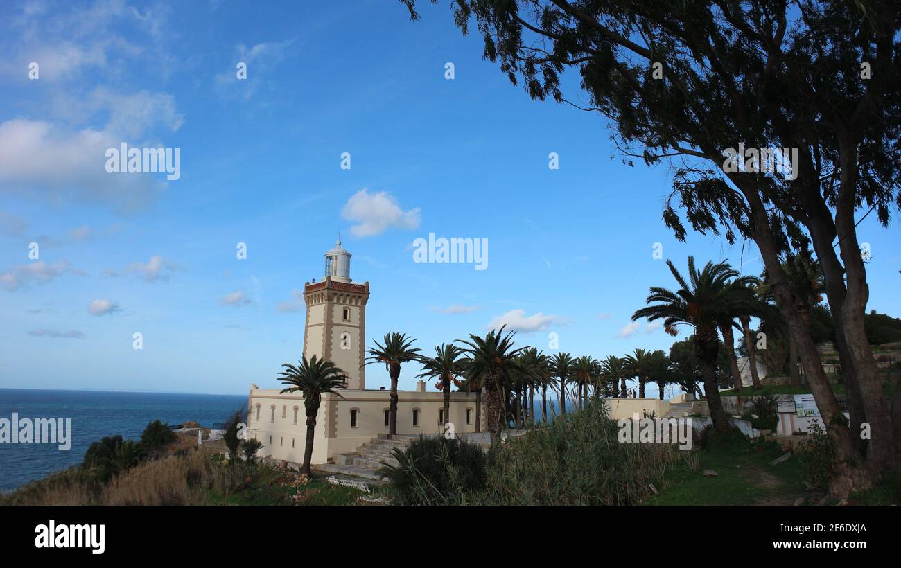 Phare Cap Spartel Light House sur l'Atlantique du Maroc près de Tanger. Entouré de palmiers et d'un ciel bleu brillant. Banque D'Images