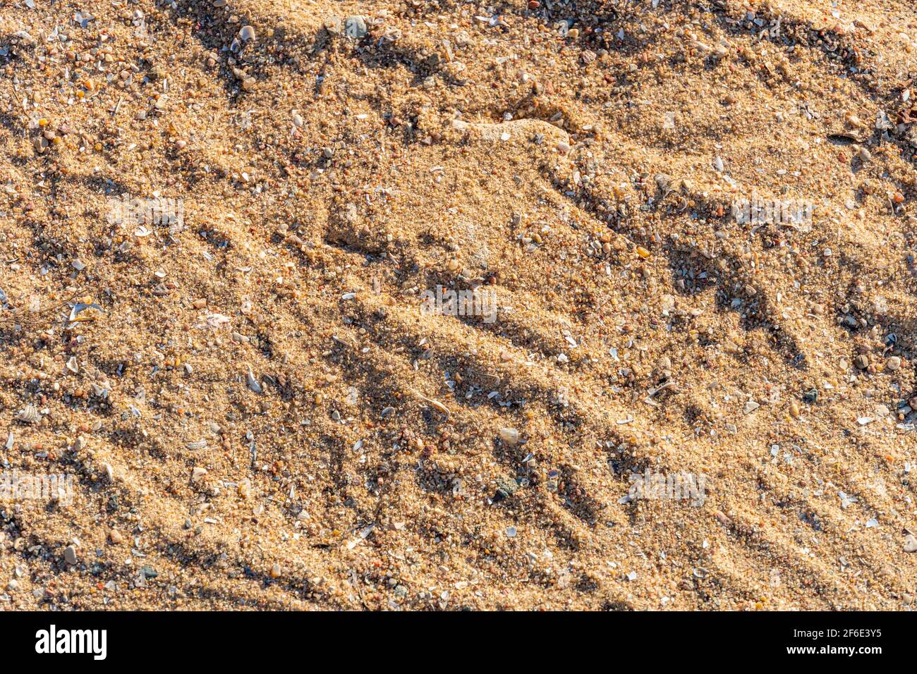 Texture de sable sur la plage au coucher du soleil, fond de sable, motif de sable inégal Banque D'Images