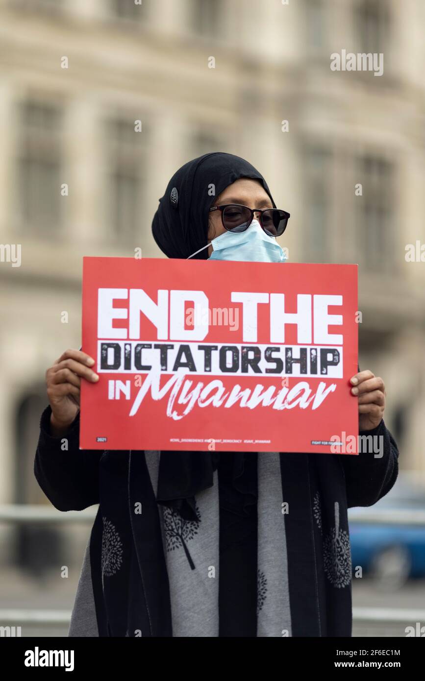 Londres, Royaume-Uni. 31 mars 2021. Un manifestant avec un écriteau intitulé « mettre fin à la dictature au Myanmar » sur la place du Parlement. Les manifestants se sont rassemblés sur la place du Parlement - portant un masque facial et observant les distances sociales - avant de marcher vers l'ambassade chinoise en solidarité avec le peuple du Myanmar contre le coup d'État militaire et les meurtres de civils par l'État. Des discours ont été prononcés à l'extérieur de l'ambassade. Depuis le début du coup d'État militaire le 1er février, plus de 520 personnes ont été tuées au Myanmar par les forces de sécurité. Samedi dernier a été le jour le plus violent où plus de 100 personnes ont été tuées. Banque D'Images