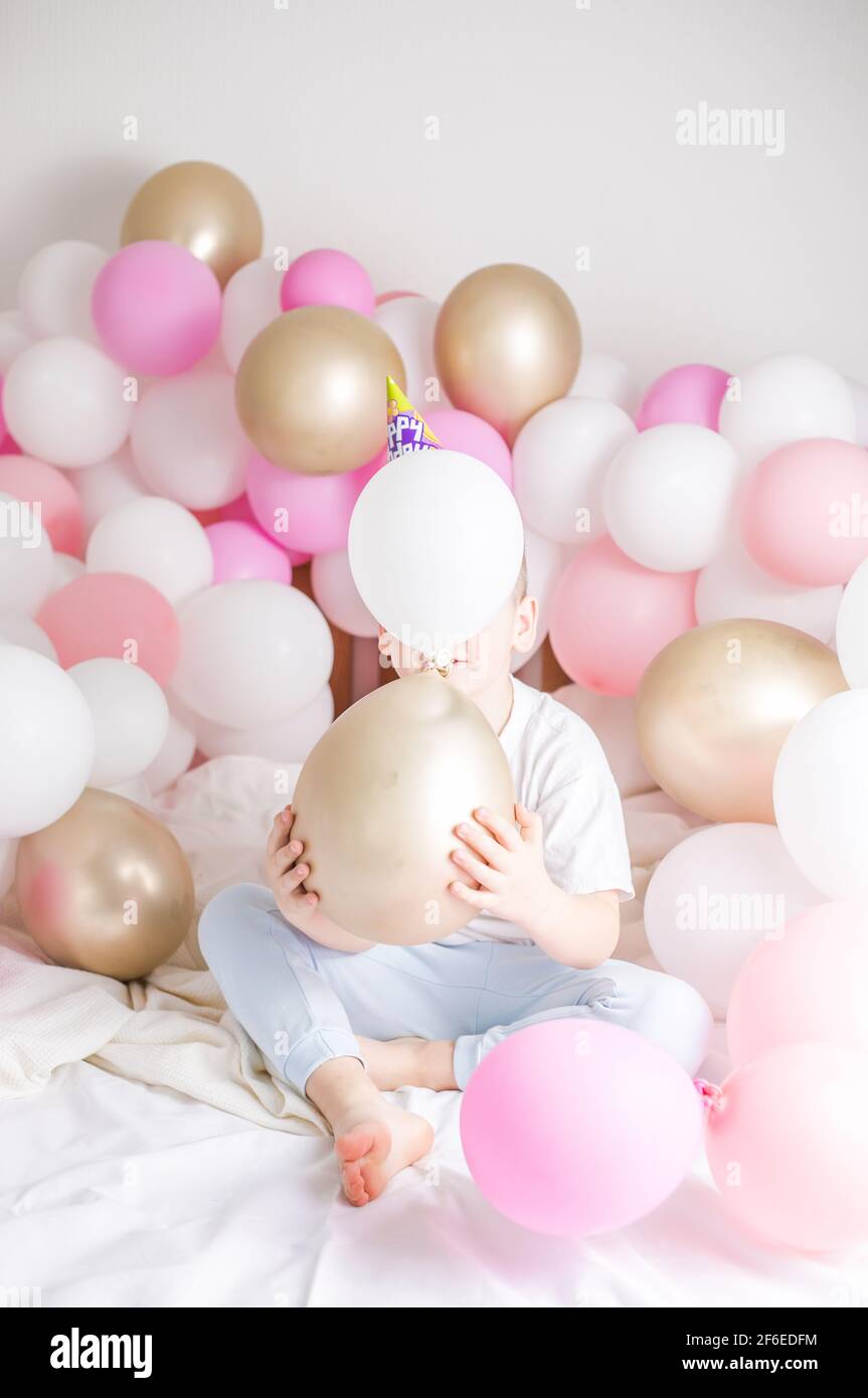 Un enfant sans visage derrière un ballon à hélium fête son anniversaire sur  fond blanc avec de nombreuses ballons. Concept de fête Photo Stock - Alamy