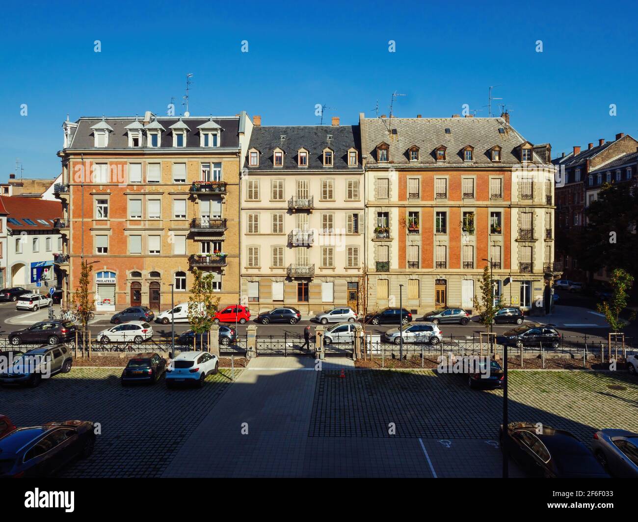 Vue d'en haut sur les bâtiments typiques de l'immobilier français Rue du Fosse des Treize avec voitures garées et ciel bleu clair Banque D'Images