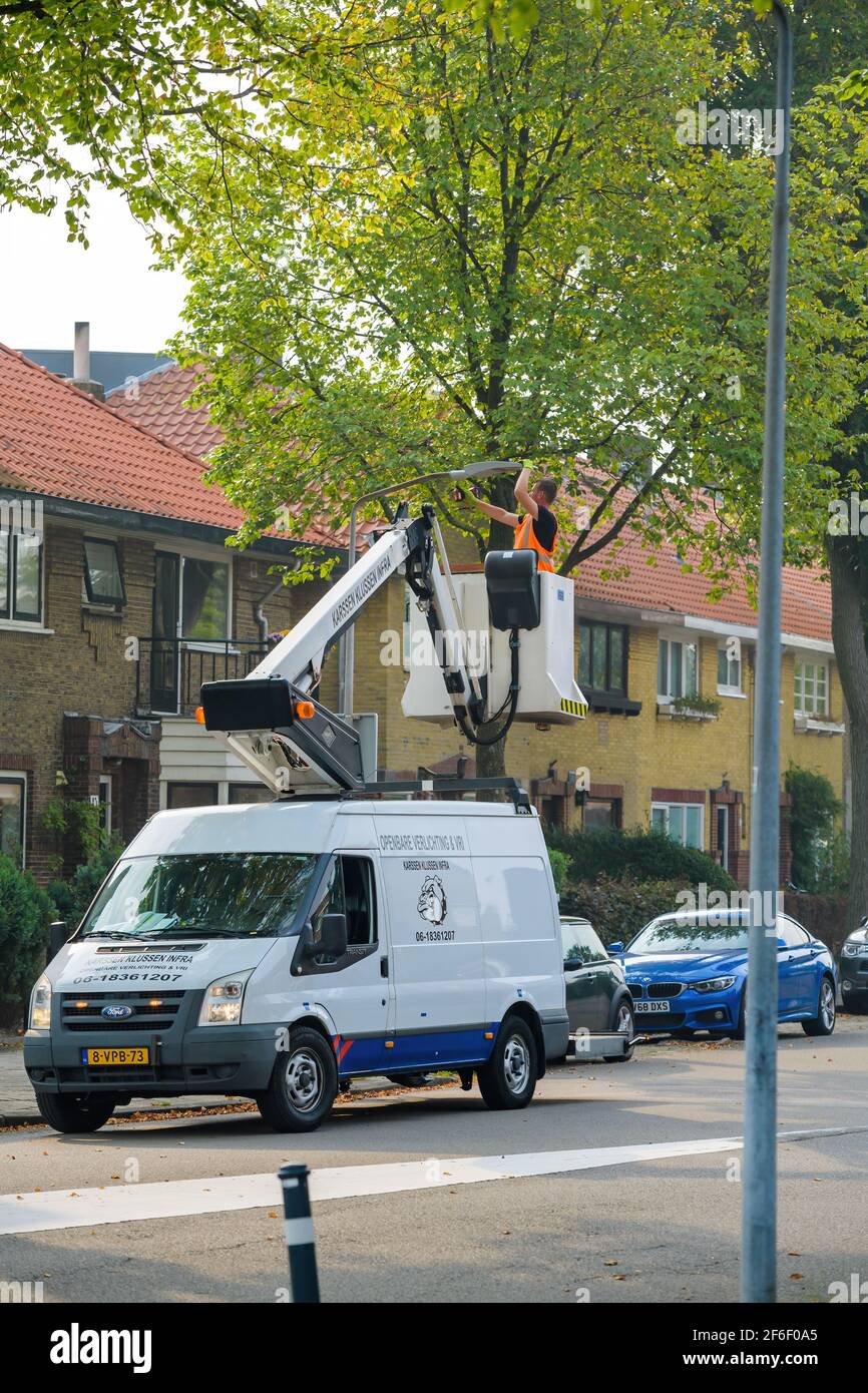 Haarlem Dutch Street avec minibus avec plateforme de haut niveau réparer le mât d'éclairage public dans un quartier calme Banque D'Images
