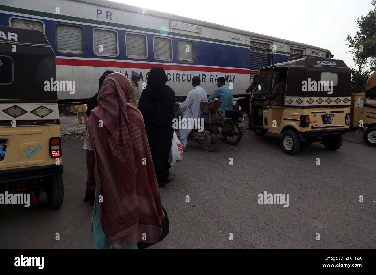 Chemin de fer circulaire de Karachi (KCR) train en route tandis que les navetteurs se tenant près du train sans barrière de sécurité qui peut causer tout incident grave, montrant la négligence du département concerné, situé sur la colonie de Machhar à Karachi le mercredi 31 mars 2021. Banque D'Images