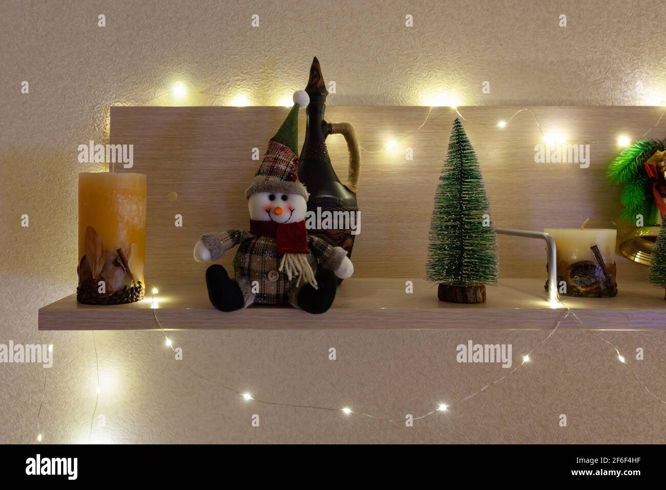 Sapin de Noël, bonhomme de neige et bougie sur l'étagère Banque D'Images