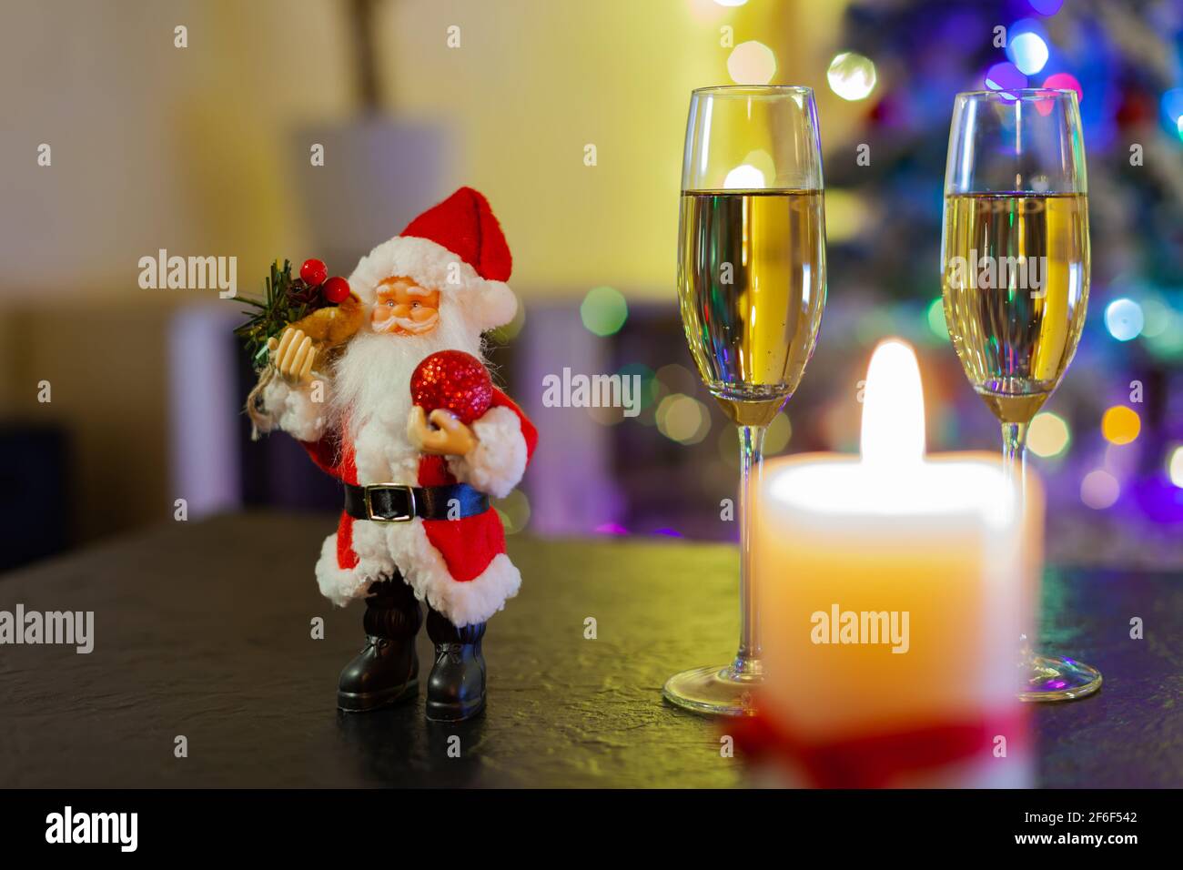 Le Père Noël et deux verres de champagne sur fond De lumières d'arbre de Noël Banque D'Images