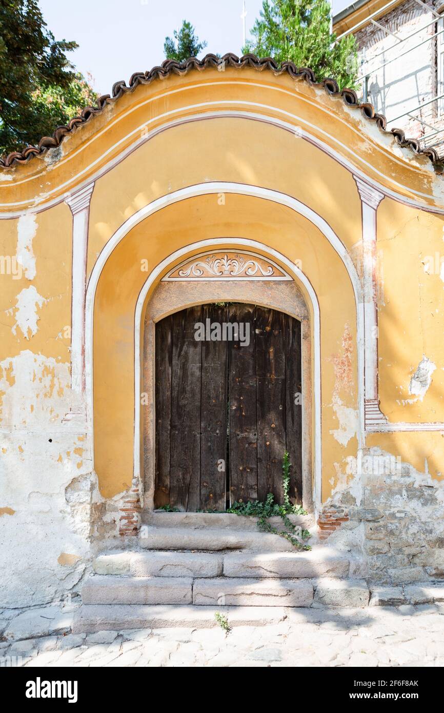 Porte dans un mur peint jaune, vieille ville de Plovdiv, Bulgarie Banque D'Images