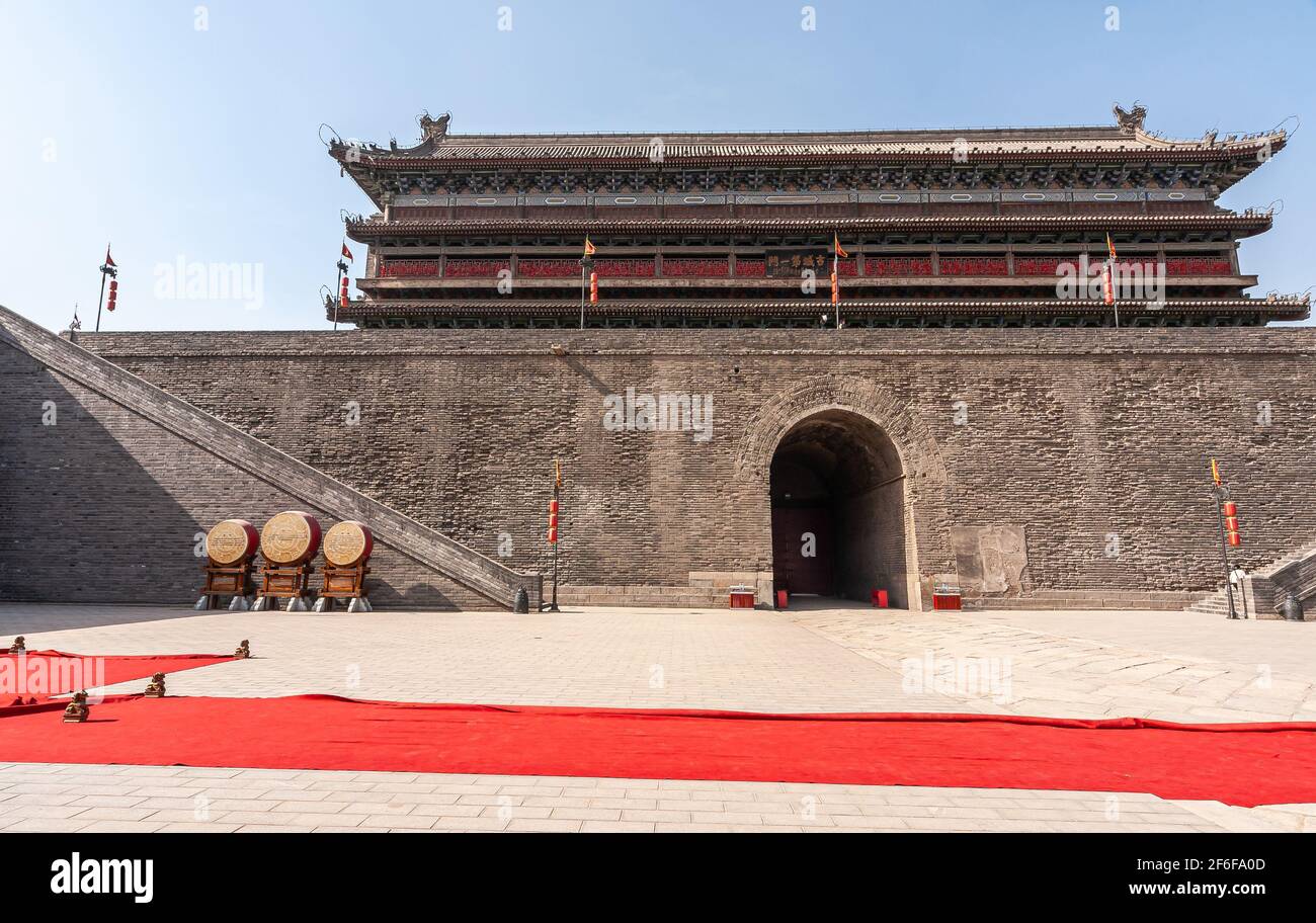 Xian, Chine - 30 avril 2010 : cérémonie à la porte nord du mur de la ville de Shuncheng. Moquette rouge sur plancher beige de grande serrure de commande avec grand bâtiment en b Banque D'Images
