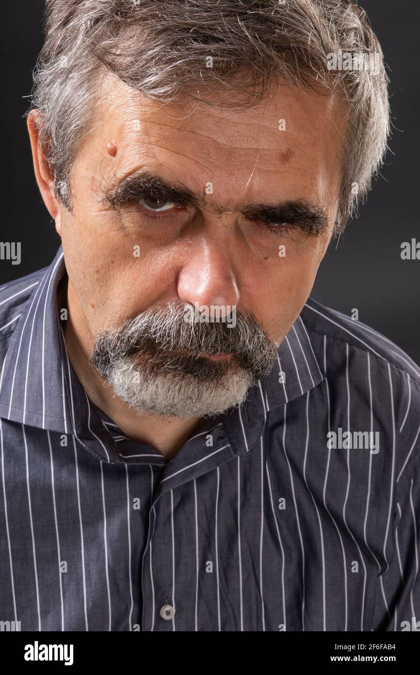 Homme âgé aux cheveux gris en colère, qui a l'air sulfuré Banque D'Images