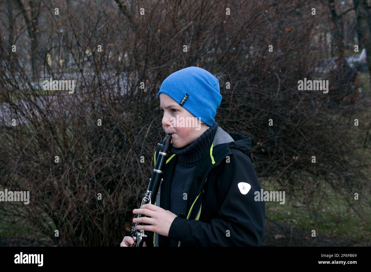 Dnepropetrovsk, Ukraine - 03.29.2021: Un garçon dans le parc joue la clarinette. L'enfant est de bonne humeur. Banque D'Images