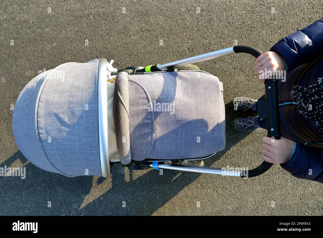 Coup de tête d'une femme marchant avec une poussette de bébé. Banque D'Images