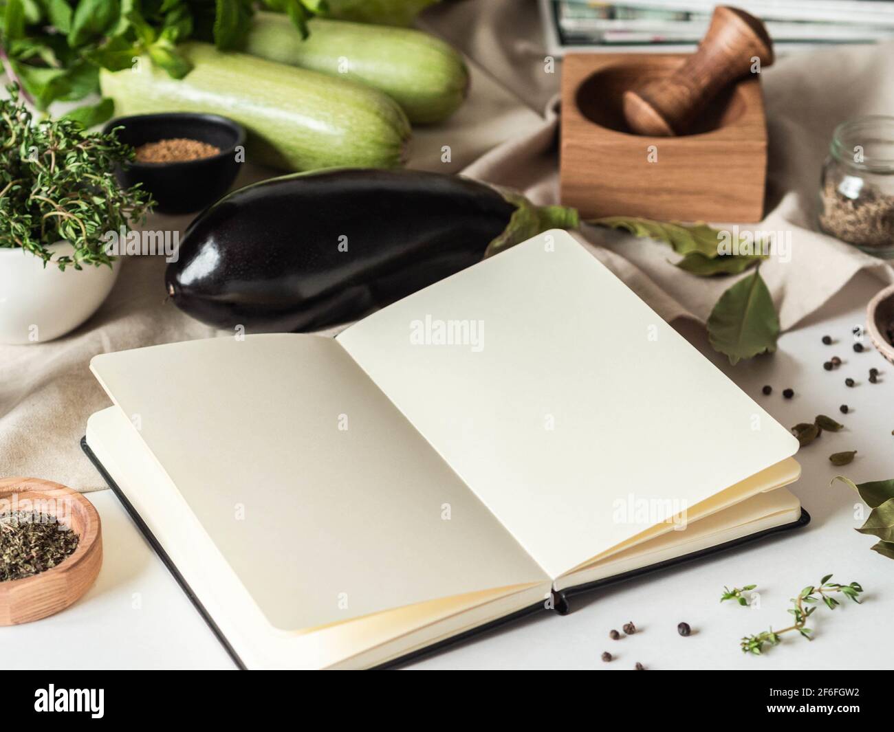Carnet ouvert pour les recettes de cuisine et divers ingrédients végétariens sur la table de cuisine. Vue avant Banque D'Images