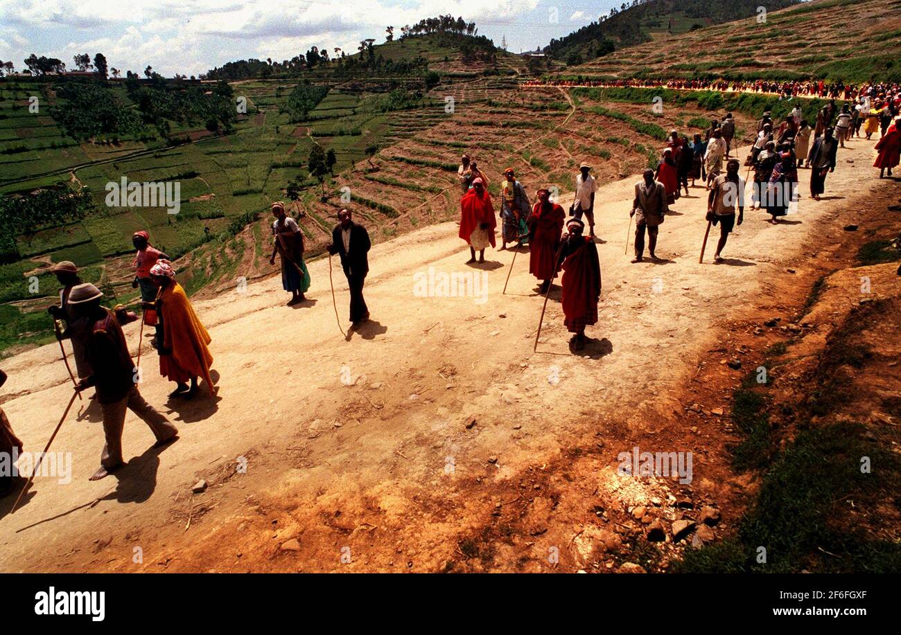 Les gens qui ont été installés de force le 1999 février dans le cadre du programme de villageois « controversé », faisant la queue pour des couvertures de savon et des jerricans au camp de Mucaca après avoir marché depuis leurs villages périphériques. Le camp était un camp de personnes déplacées et abritait jusqu'à récemment 45,000 personnes. Il est maintenant utilisé comme centre de distribution pour l'aide. Il se trouve dans la commune de Cyeru, province de Ruhengeri, Nord-Ouest du Rwanda.14.2.1999 Photo : JOHN VOOS Banque D'Images