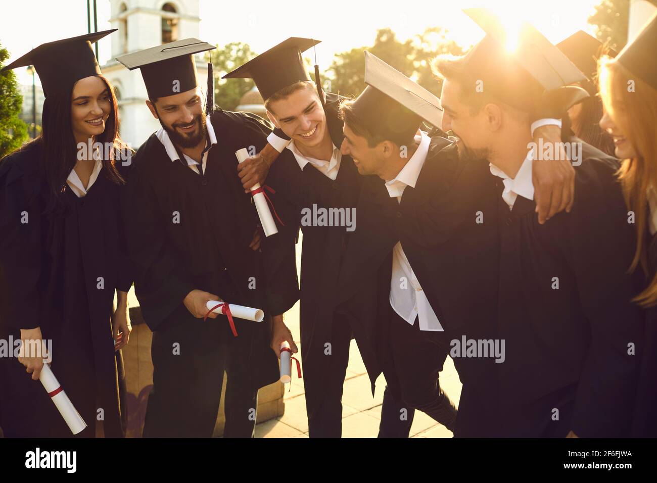 Les diplômés des universités les plus heureux et les plus performants dans les villes universitaires détiennent des diplômes entre leurs mains et leurs hug. Banque D'Images