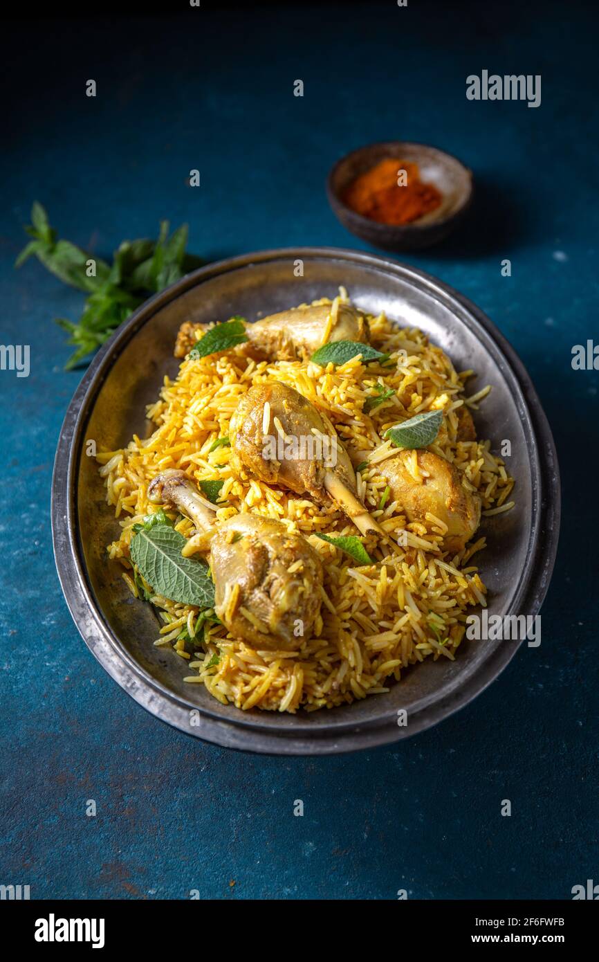Cuisine indienne ou pakistanaise. Biriany de riz Biryani aux herbes de menthe et au pain naan sur fond bleu Banque D'Images