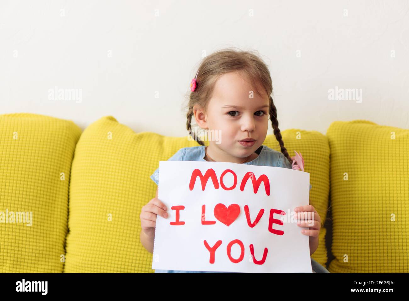 Petite fille d'âge préscolaire souriante tenant une carte de voeux pour la  fête des mères heureuse avec coeur rouge dessiné. Aimer le bébé caucasien  souhaite maman joyeux anniversaire Photo Stock - Alamy