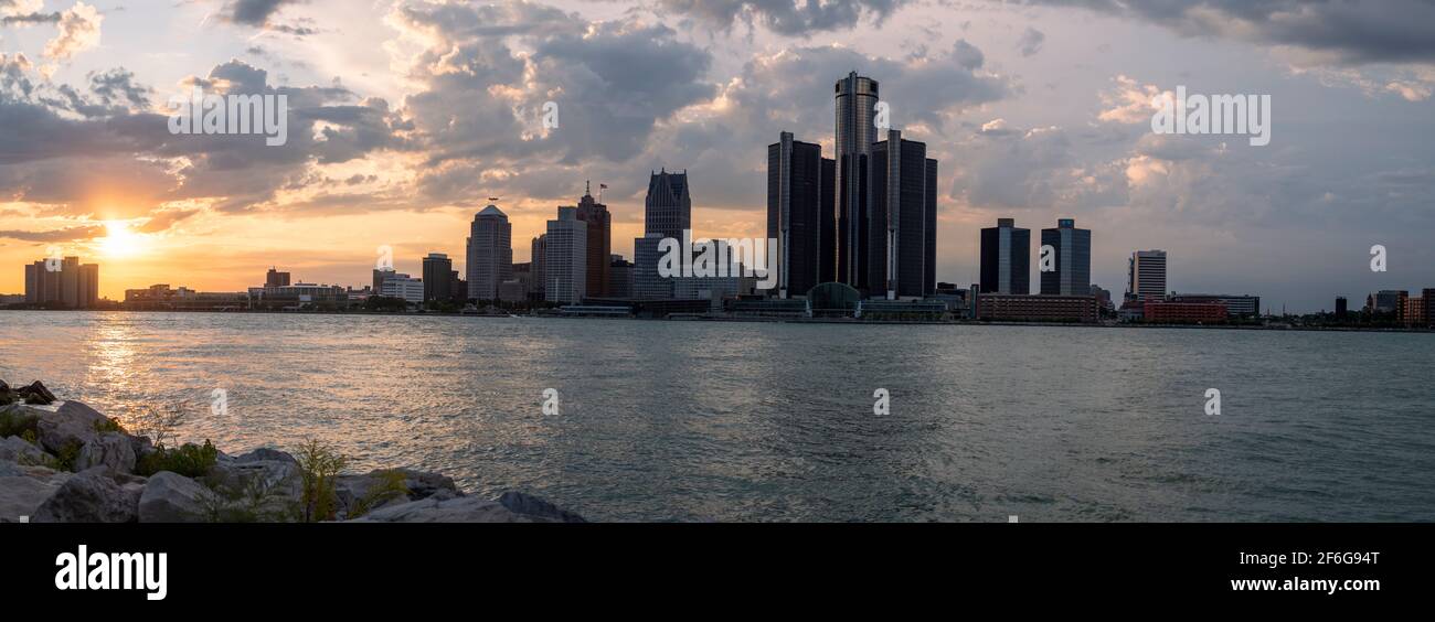 Detroit Skyline fom Windsor, Canada: Alors que le soleil se couche, les hauts bâtiments dominés par la tour GM à Detroit sont partiellement silhouettés contre un ciel rempli de nuages. Banque D'Images