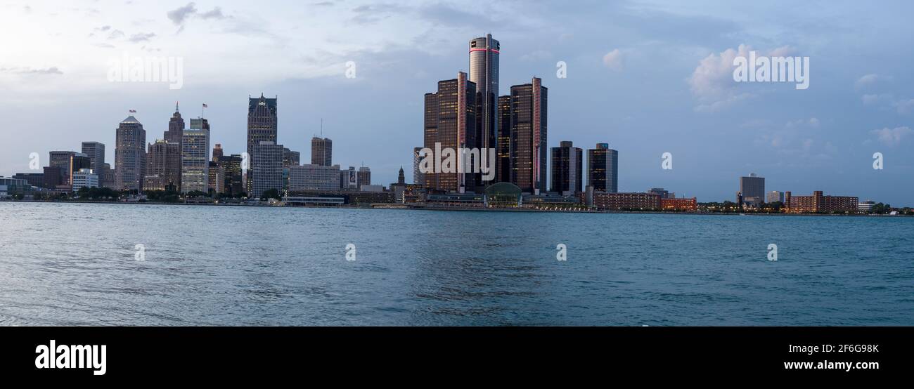 Detroit Skyline au crépuscule Windsor, Canada : après le coucher du soleil, les hauts bâtiments dominés par la tour GM de Detroit commencent à s'allumer. Rivière Detroit en premier plan. Banque D'Images