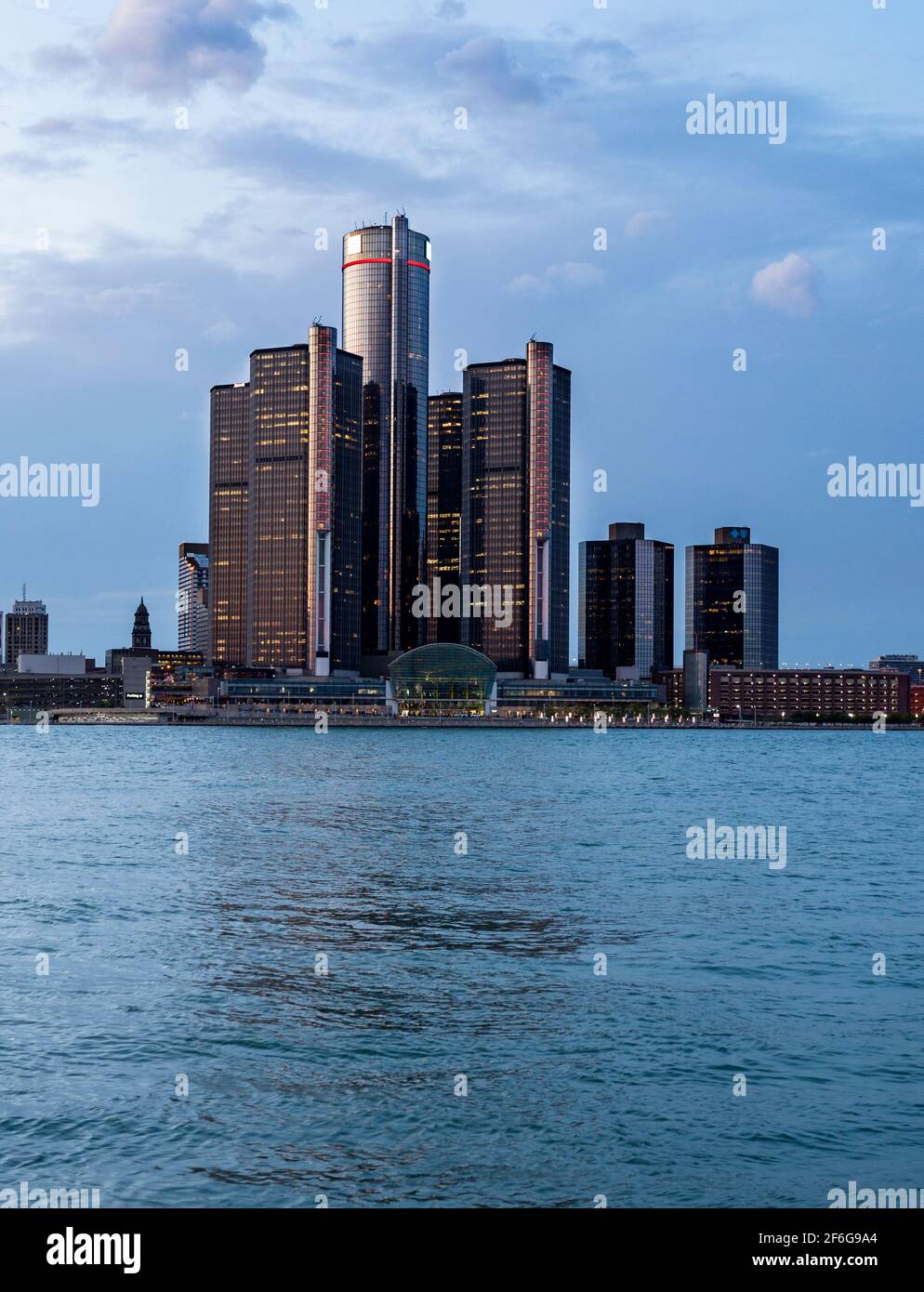 Feux allumés au Renaissance Centre de Detroit : après le coucher du soleil, les hauts bâtiments du Renaissance Centre dominés par la tour GM de Detroit commencent à s'allumer. Rivière Detroit en premier plan. Banque D'Images