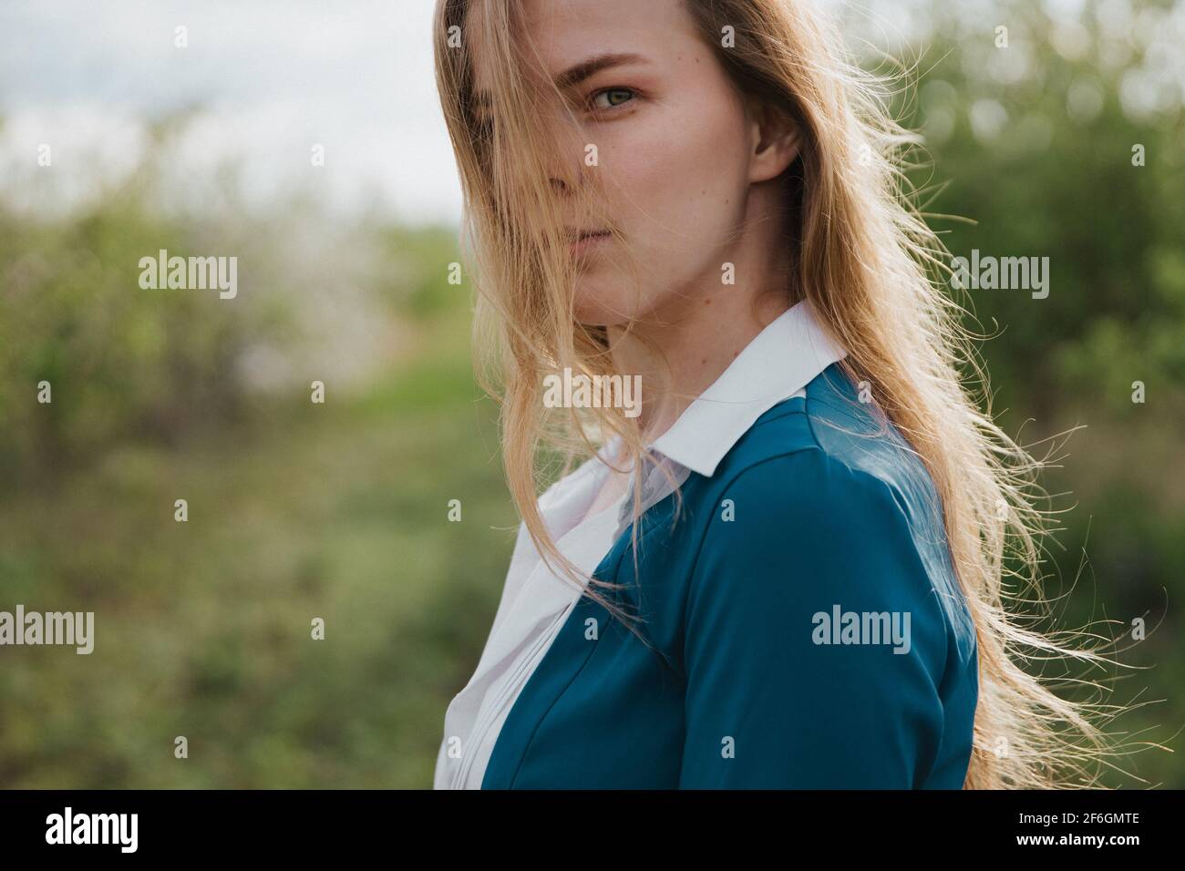 Une jeune femme regarde à travers ses cheveux à la visionneuse. Banque D'Images