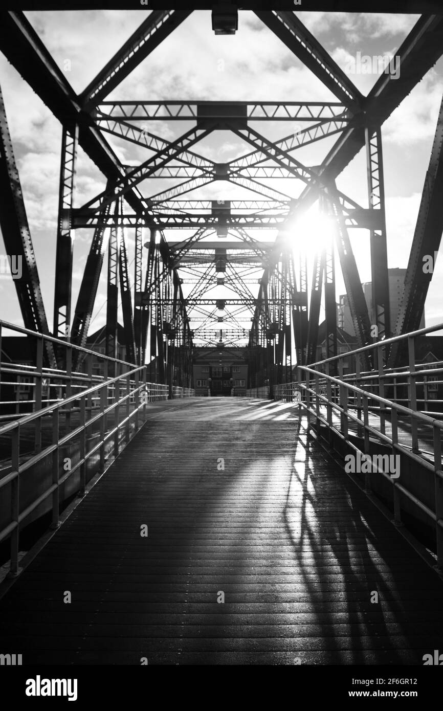 Grande passerelle en acier rouge à Salford Quays Manchester sur UN Jour couvert le soleil Shining à travers le travail de métal Banque D'Images