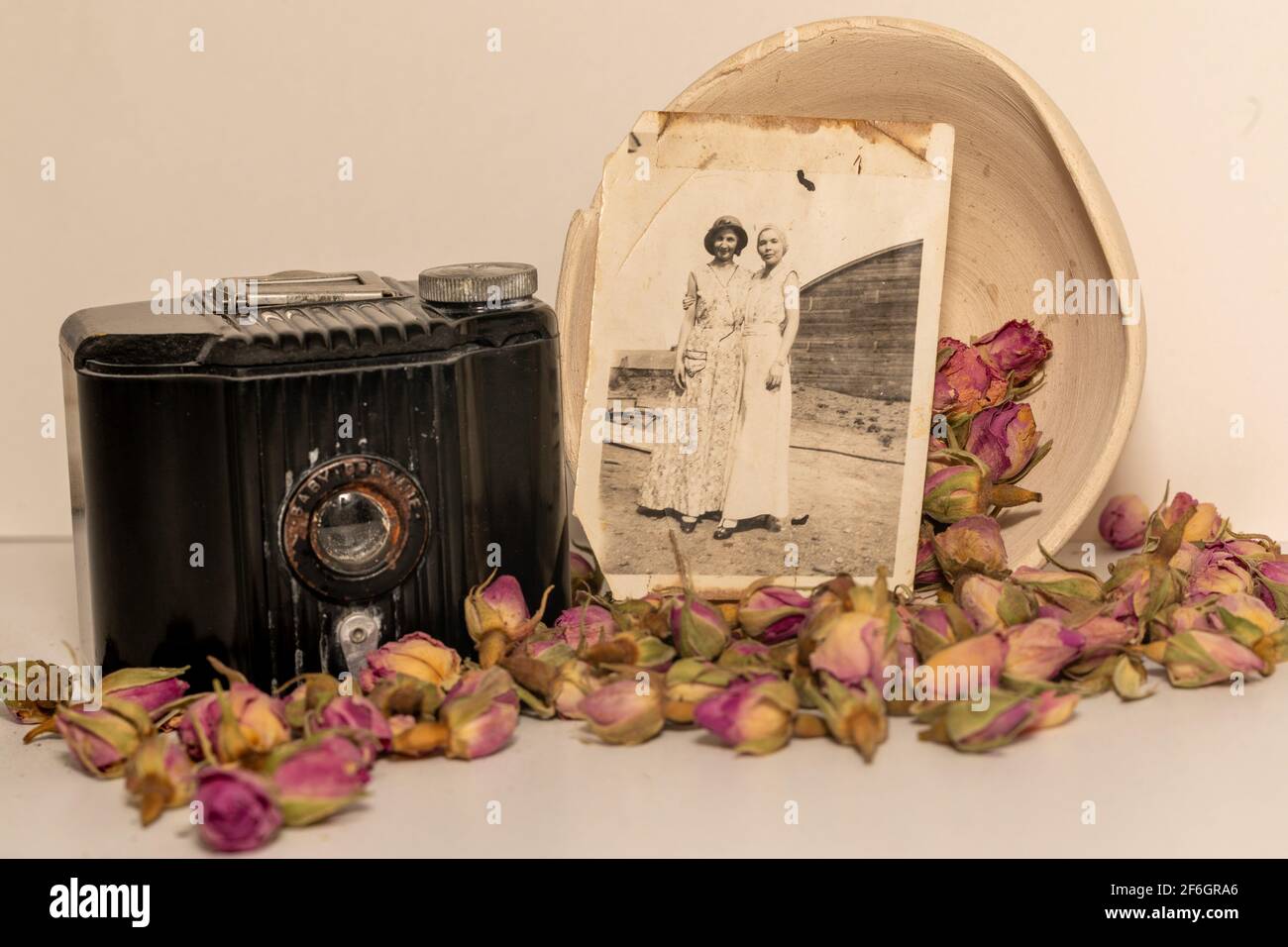 vieux souvenirs; vieux bébé de grand-mère brownie appareil photo, les photos anciennes, et les roses séchées. Banque D'Images