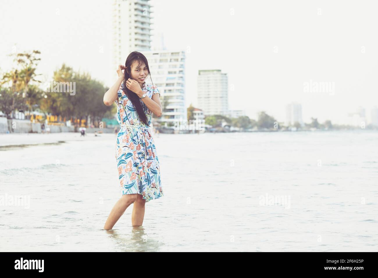 La belle femme thaïlandaise pose sur la rive, ses longs cheveux coulant  derrière elle.Hua Hin Thaïlande Photo Stock - Alamy
