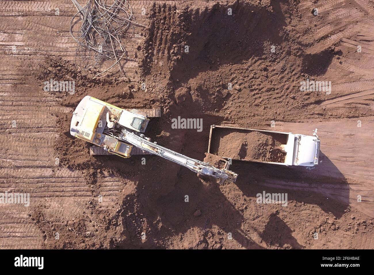 Pelle hydraulique chargeant le sol sur un camion-benne sur un nouveau site de développement. Banque D'Images