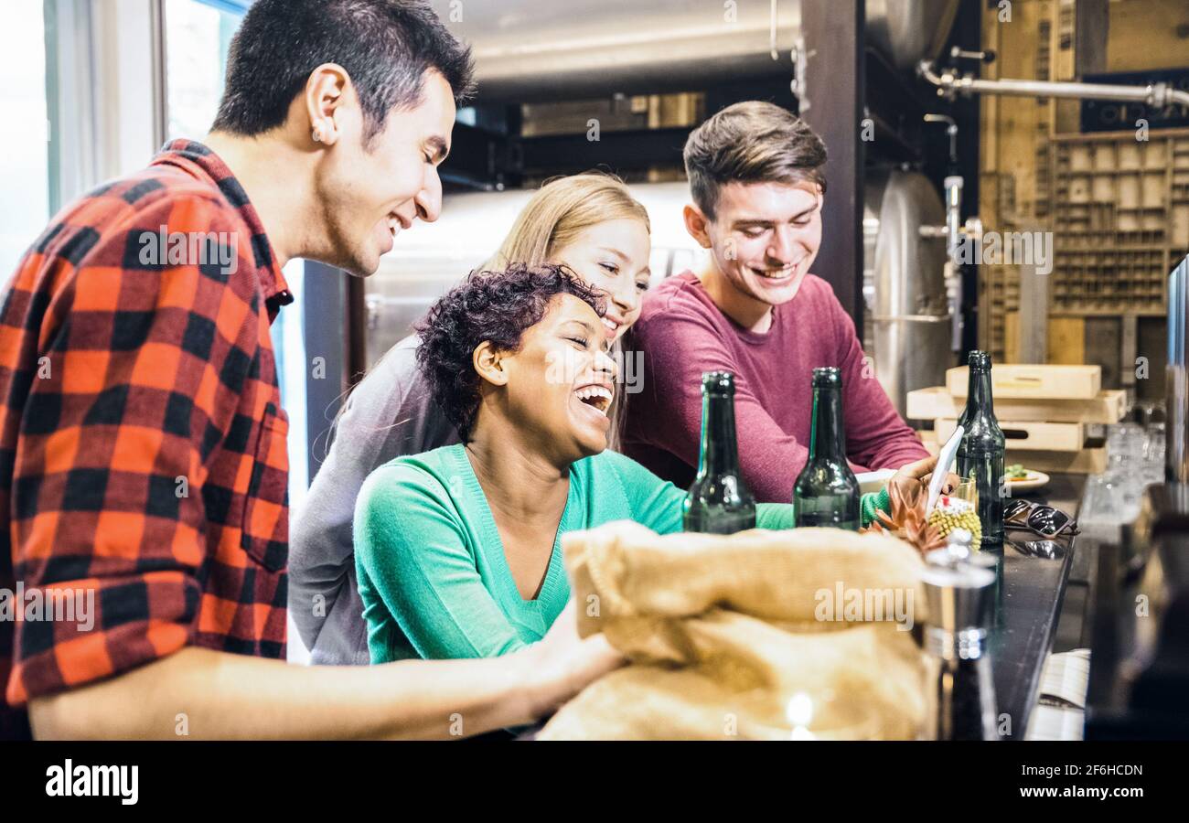 Amis multiraciaux qui boivent de la bière et s'amusent avec un téléphone portable Au bar de bière de brasserie - concept d'amitié sur les jeunes passer du temps ensemble Banque D'Images