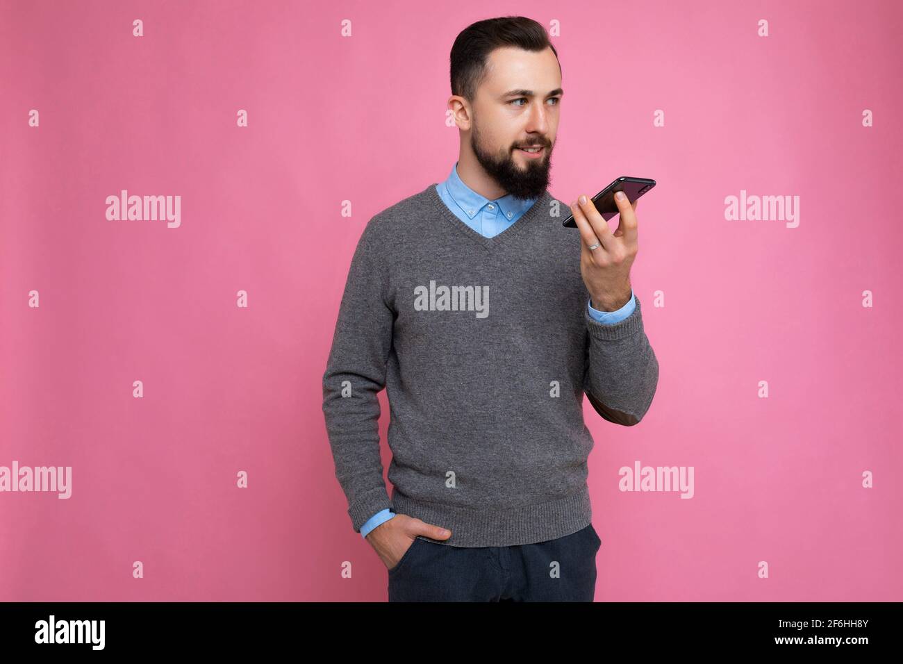 Photo prise de beau positif belle apparence jeune homme portant décontracté ensemble élégant poising isolé sur fond avec espace vide main dans la main Banque D'Images